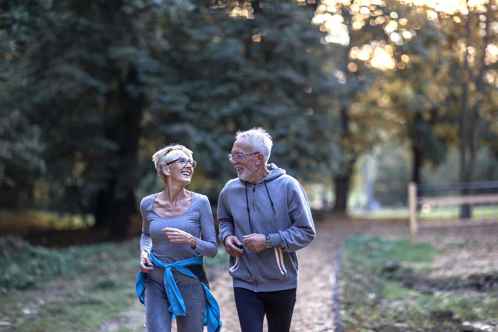 Smiling Senior Couple Jogging in the Park | Medicaid Planning in Washington​ | Legacy Law Group