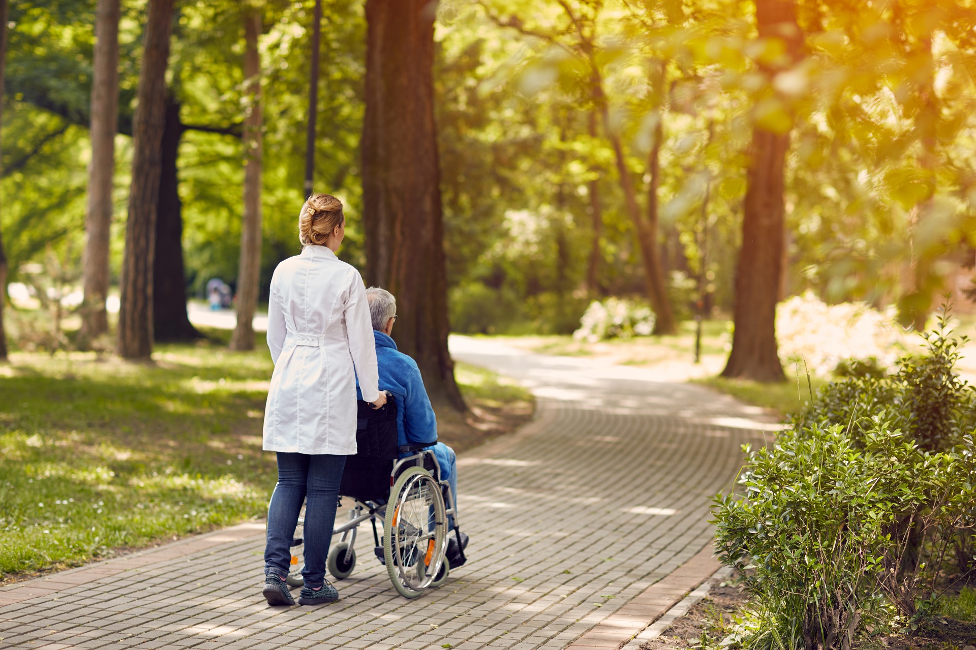 Nurse Helps Elderly Man on Wheelchair Outdoor | Medicaid Planning in Washington​ | Legacy Law Group