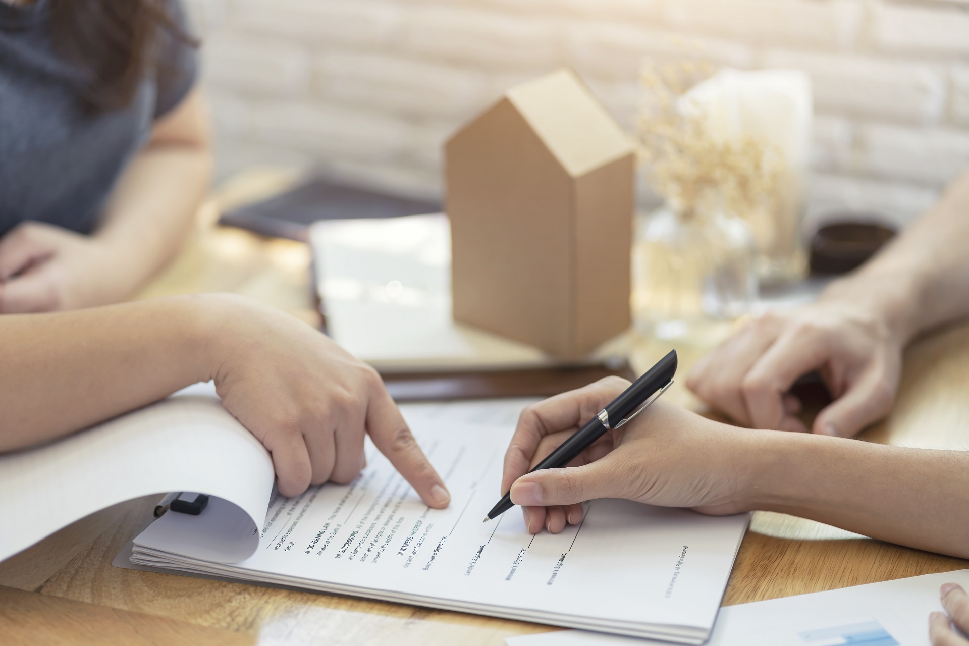 Woman Signing Legal Document for Real Estate Purchase | Estate Planning Law Firm​ | Legacy Law Group