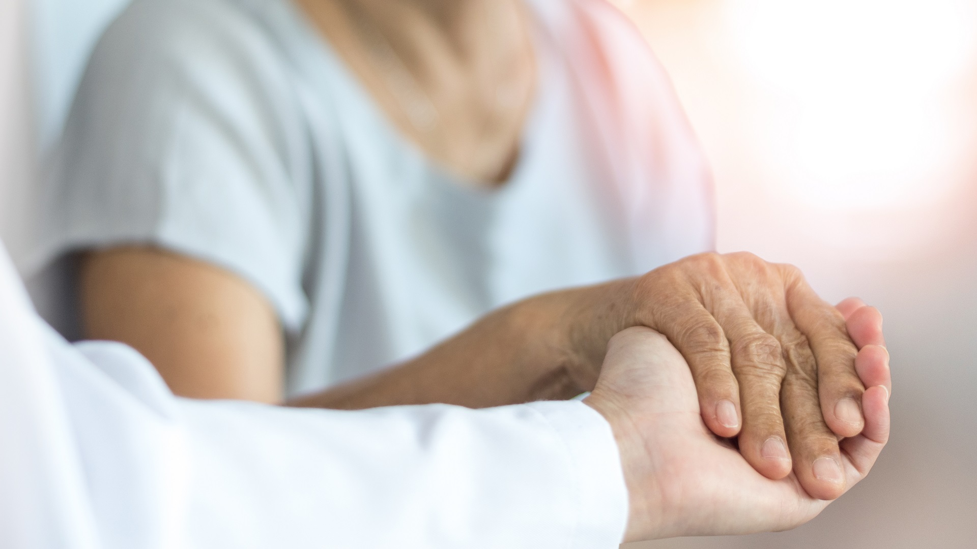 Senior Female Holding Hand With Young Caregiver | Medicaid Planning in Washington | Legacy Law Group
