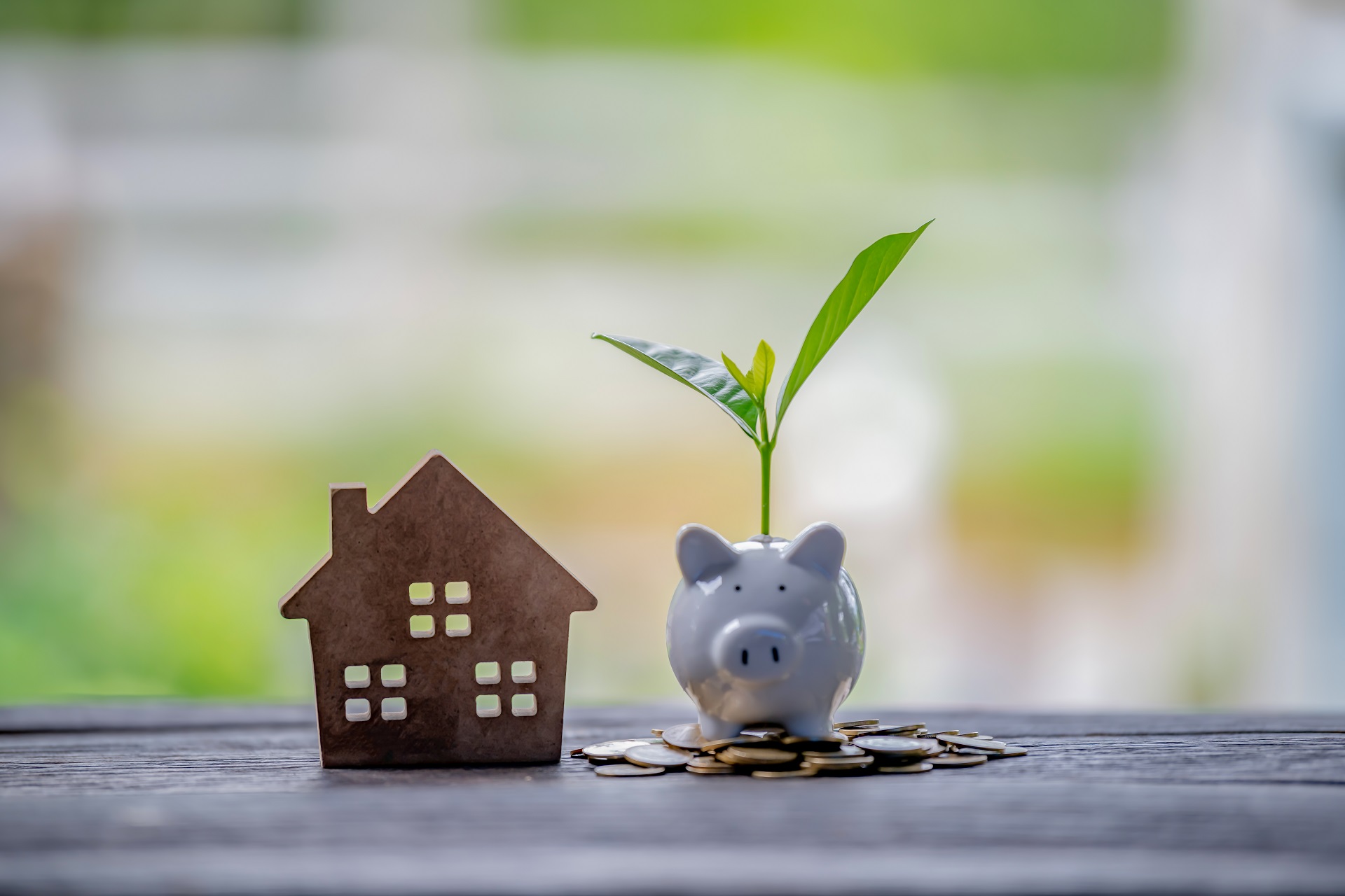 Model House With Piggybank and Coins On A Table | Estate Planning Law Firm​ | Legacy Law Group