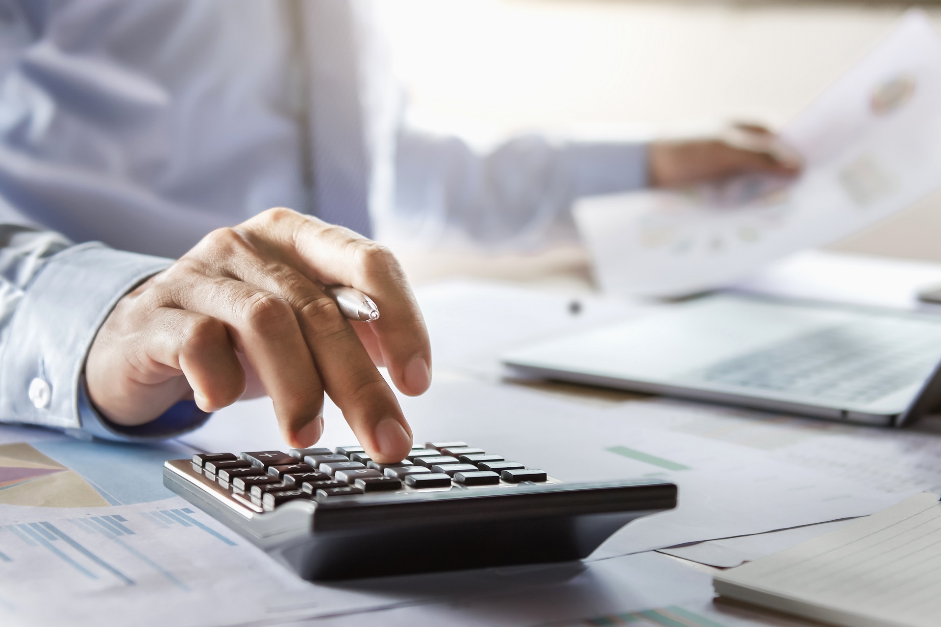 Man Calculates Finance Report In Office | Estate Planning Law Firm in Washington​ | Legacy Law Group