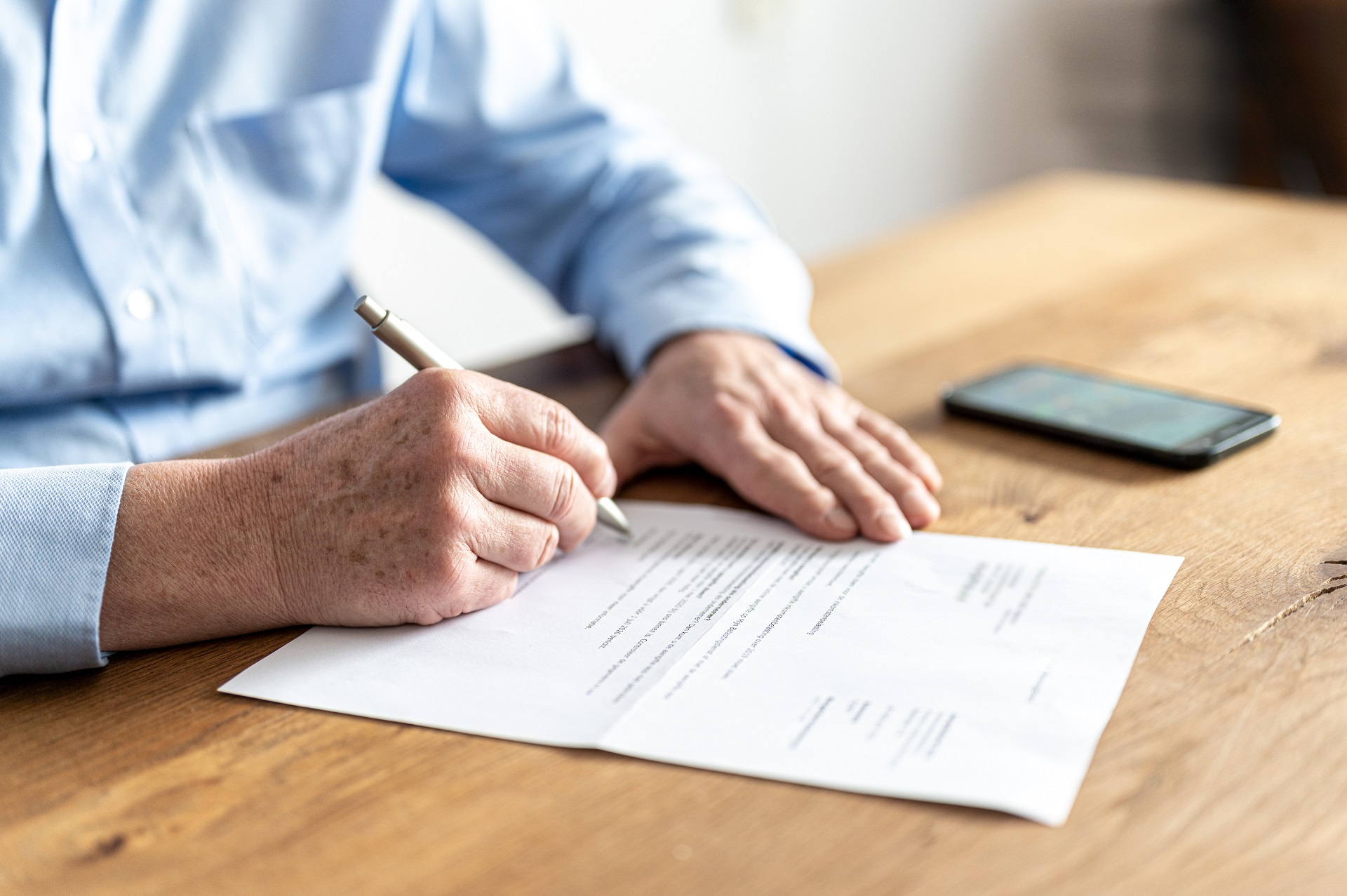 Elderly Man Signing Legal Document for Estate Planning | Elder Law Lawyer​​​ | Legacy Law Group