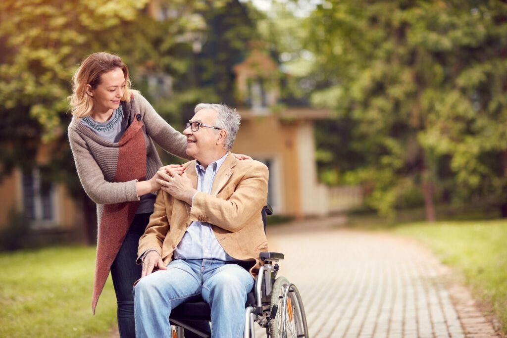 Woman standing by man in wheelchair | medicaid planning attorney​ | Legacy Law Group