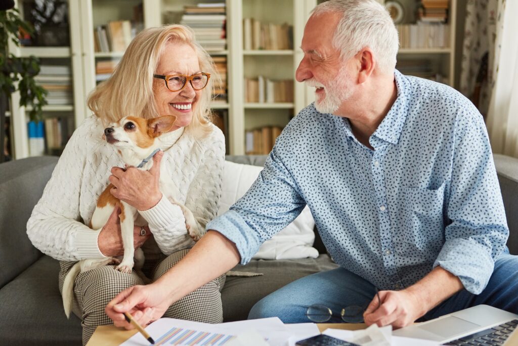 Two adults with a dog looking at documents on a sofa | elder law lawyer​ | Legacy Law Group