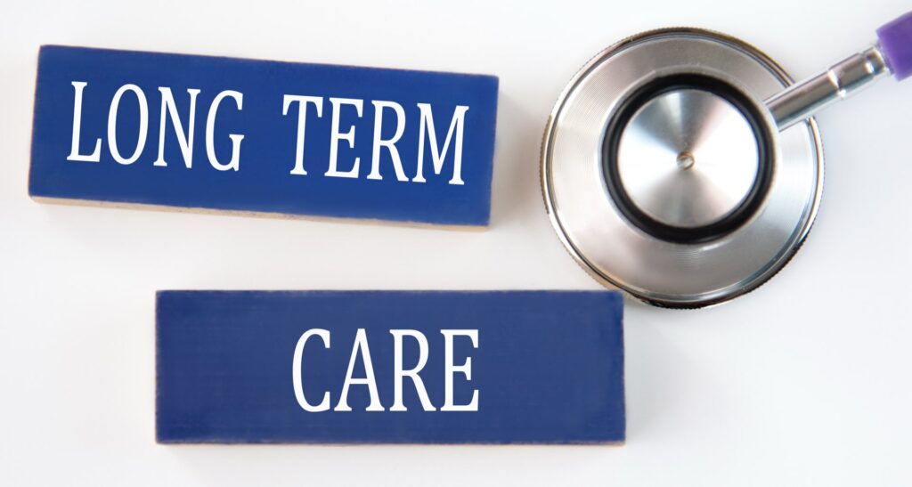 LONG TERM CARE - words on blue wooden blocks on white background with stethoscope.