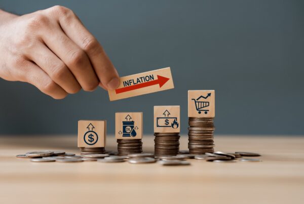 Hand putting wooden cube and inflation word a on coins